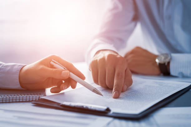istockphoto-840610244-612×612 Business people negotiating a contract. Human hands working with documents at desk and signing contract.